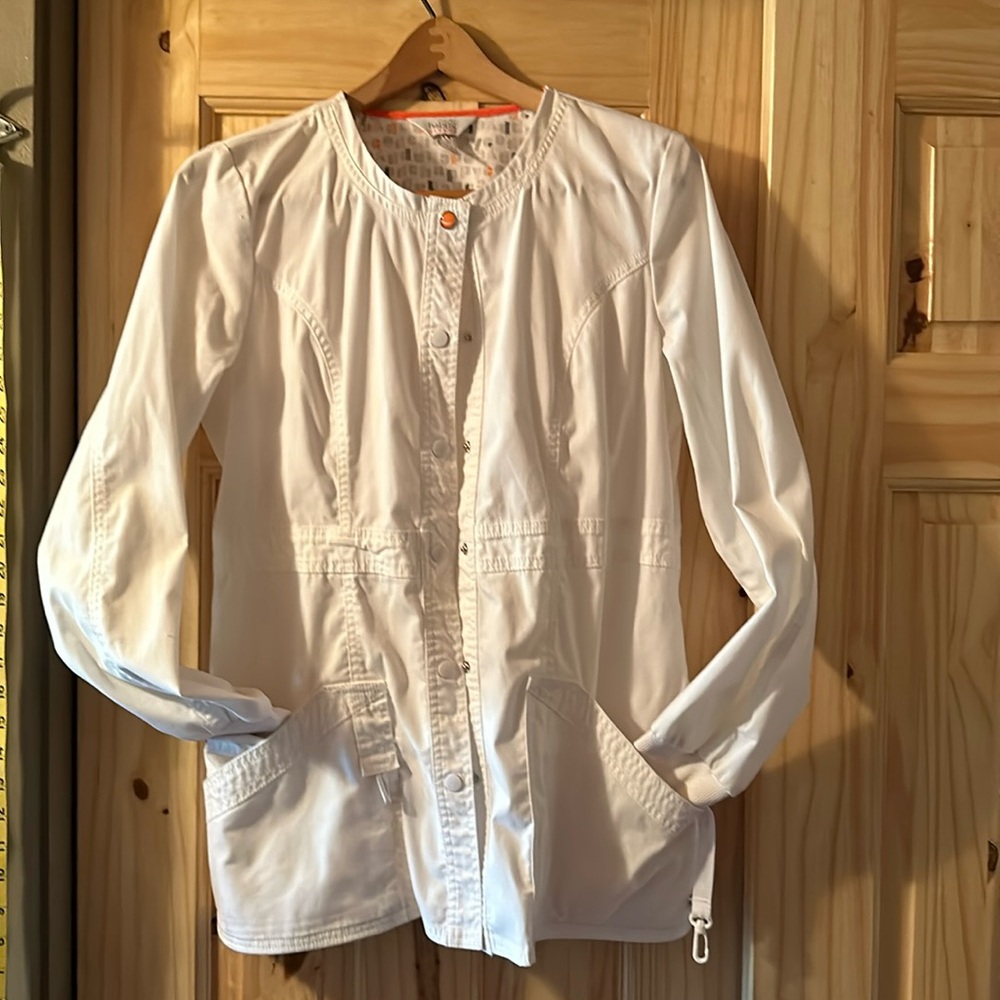 White scrub coat with orange accent button